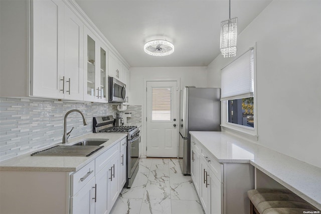 kitchen featuring pendant lighting, white cabinetry, sink, and appliances with stainless steel finishes