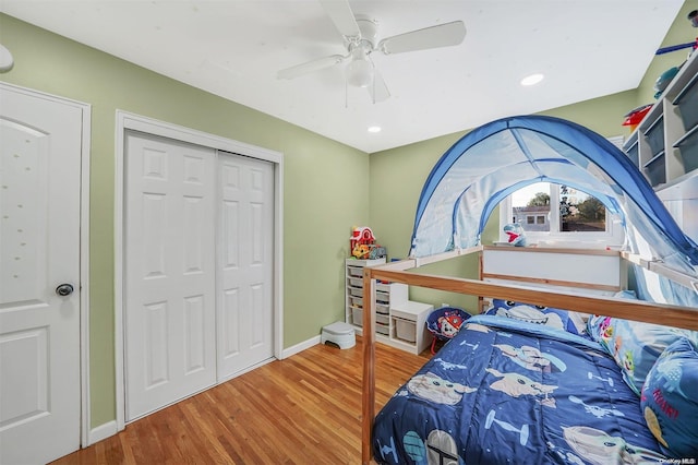 bedroom with hardwood / wood-style flooring, ceiling fan, and a closet