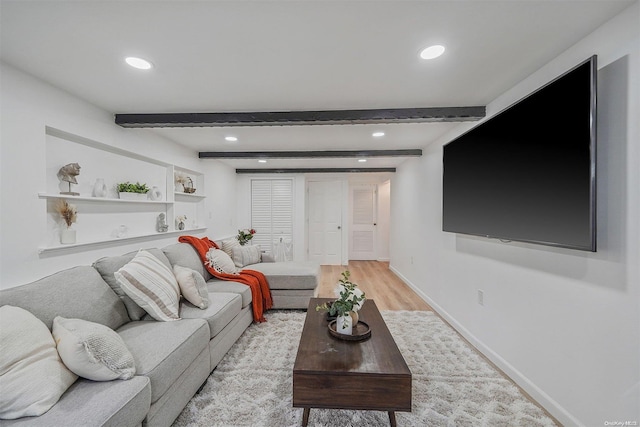 living room featuring beam ceiling and light wood-type flooring