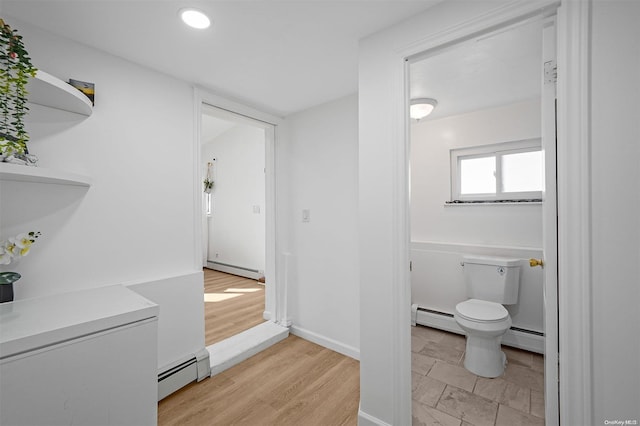 bathroom featuring wood-type flooring, a baseboard radiator, and toilet