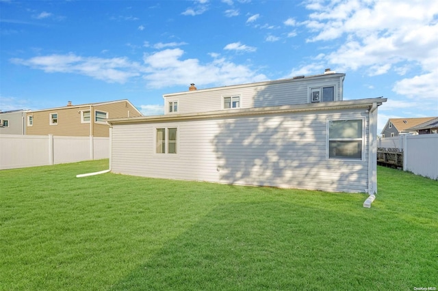 rear view of property featuring a lawn