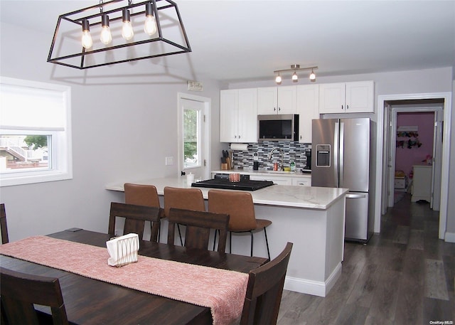 kitchen with white cabinetry, sink, stainless steel appliances, dark hardwood / wood-style flooring, and decorative backsplash