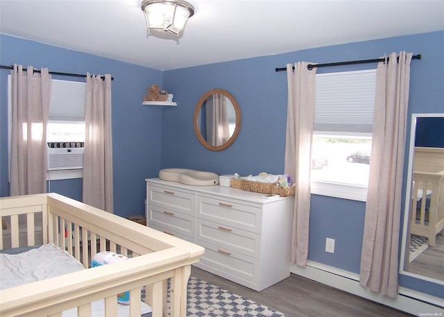 bedroom with dark hardwood / wood-style floors, cooling unit, and baseboard heating