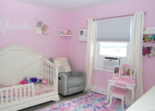 bedroom with baseboard heating, cooling unit, a nursery area, and hardwood / wood-style flooring