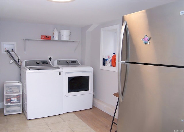 laundry room featuring washer and clothes dryer and light wood-type flooring