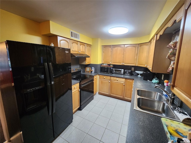 kitchen with black appliances, light tile patterned flooring, and sink