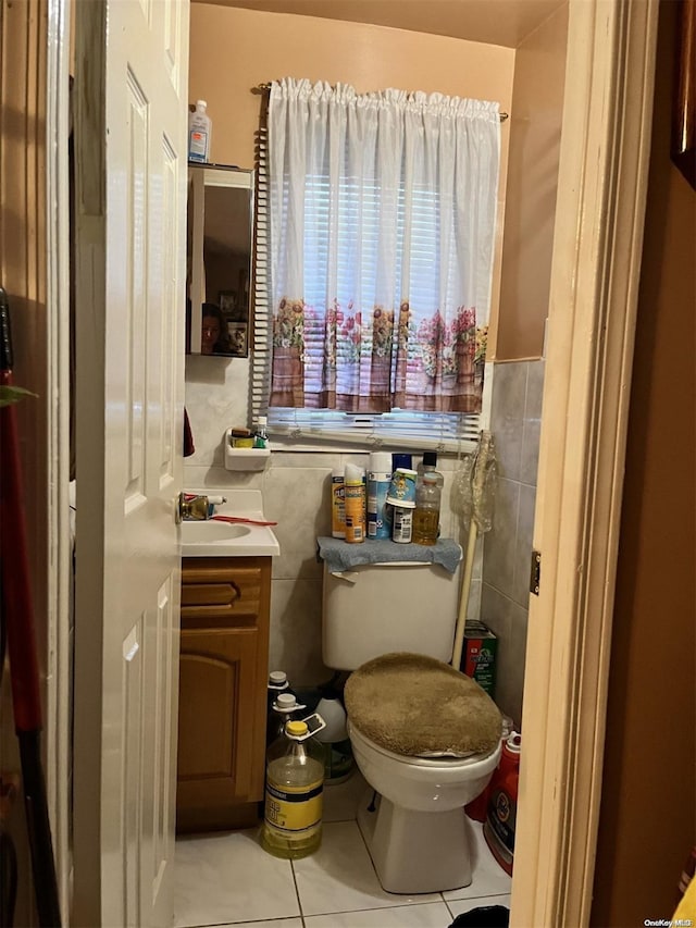 bathroom featuring tile patterned floors, vanity, tile walls, and toilet