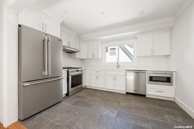 kitchen with tasteful backsplash, premium appliances, crown molding, sink, and white cabinets