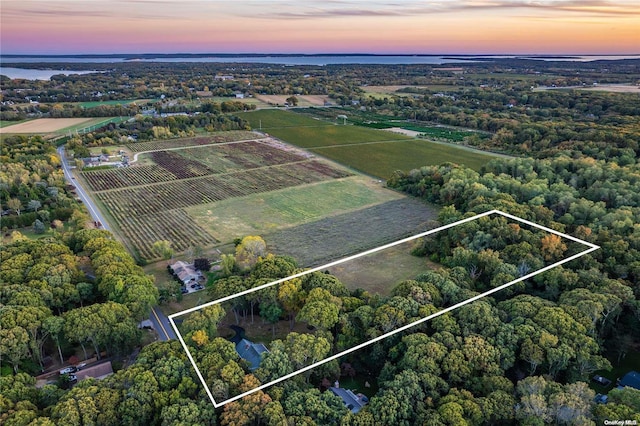 aerial view at dusk featuring a water view