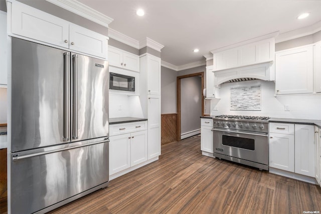 kitchen featuring dark hardwood / wood-style floors, high end appliances, white cabinetry, and baseboard heating