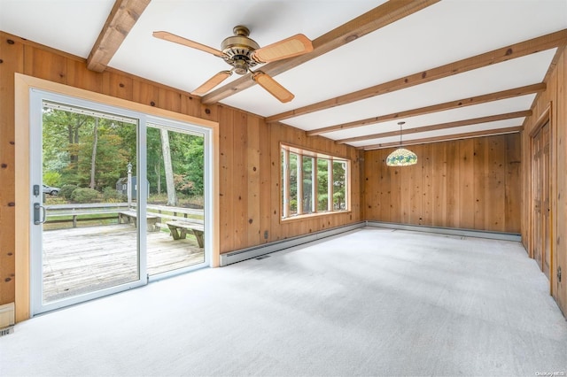 carpeted empty room featuring beam ceiling, a healthy amount of sunlight, and wood walls