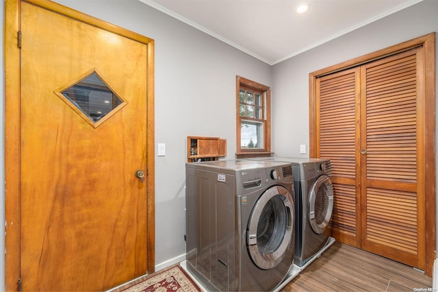 laundry area with washer and clothes dryer, light wood-type flooring, and ornamental molding