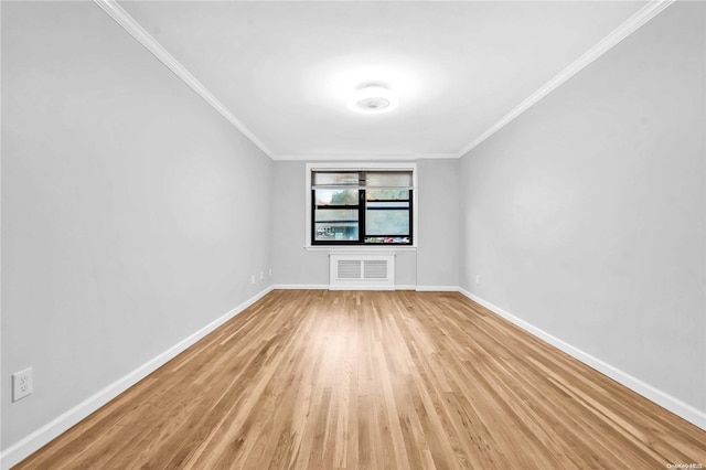 spare room featuring light hardwood / wood-style floors and ornamental molding