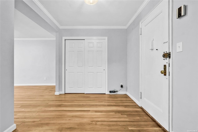 clothes washing area featuring light wood-type flooring and crown molding