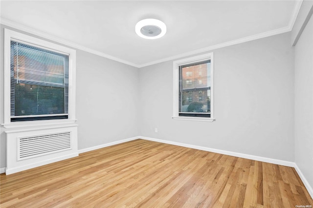 unfurnished room featuring light hardwood / wood-style floors and crown molding