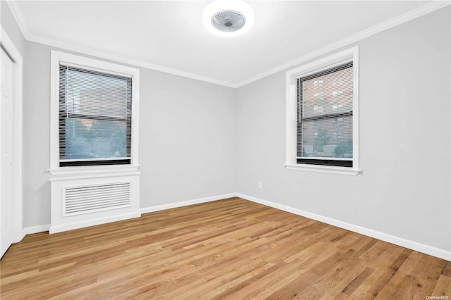 unfurnished room with light hardwood / wood-style flooring, a wealth of natural light, and crown molding