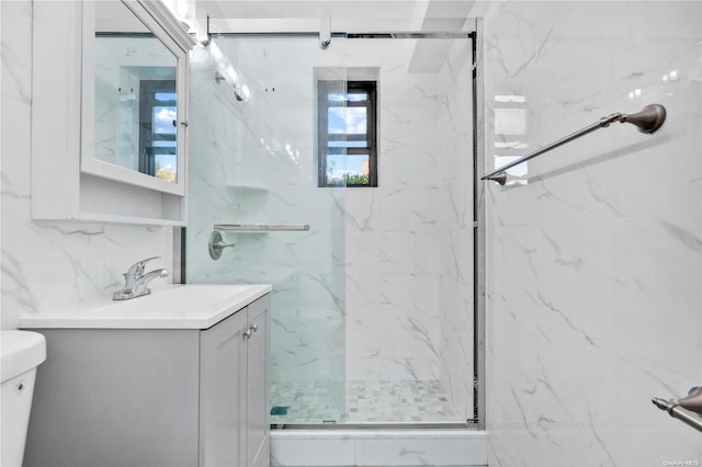 bathroom featuring backsplash, toilet, a shower with door, vanity, and tile walls