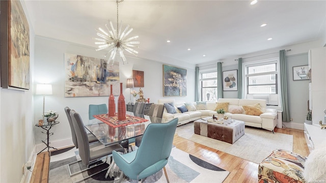 dining area featuring ornamental molding, a notable chandelier, and light wood-type flooring