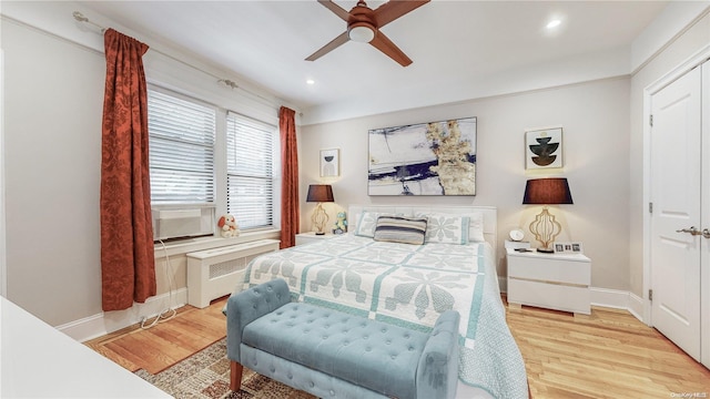 bedroom with radiator, ceiling fan, a closet, and light wood-type flooring