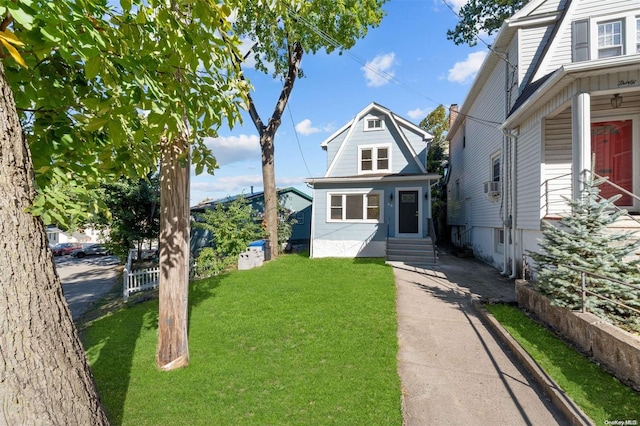 bungalow featuring cooling unit and a front lawn