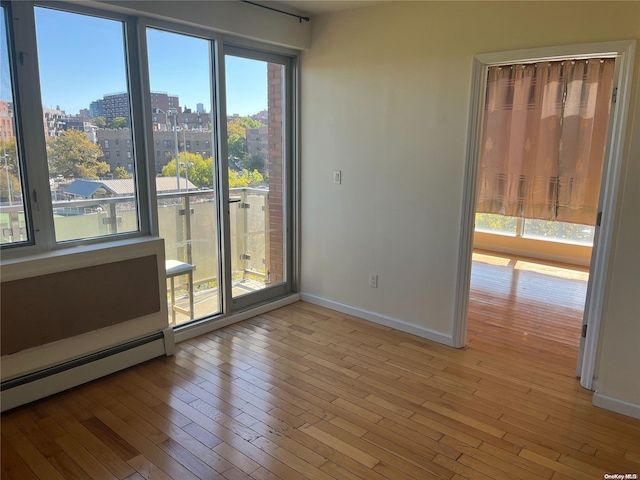 spare room featuring light hardwood / wood-style floors and baseboard heating