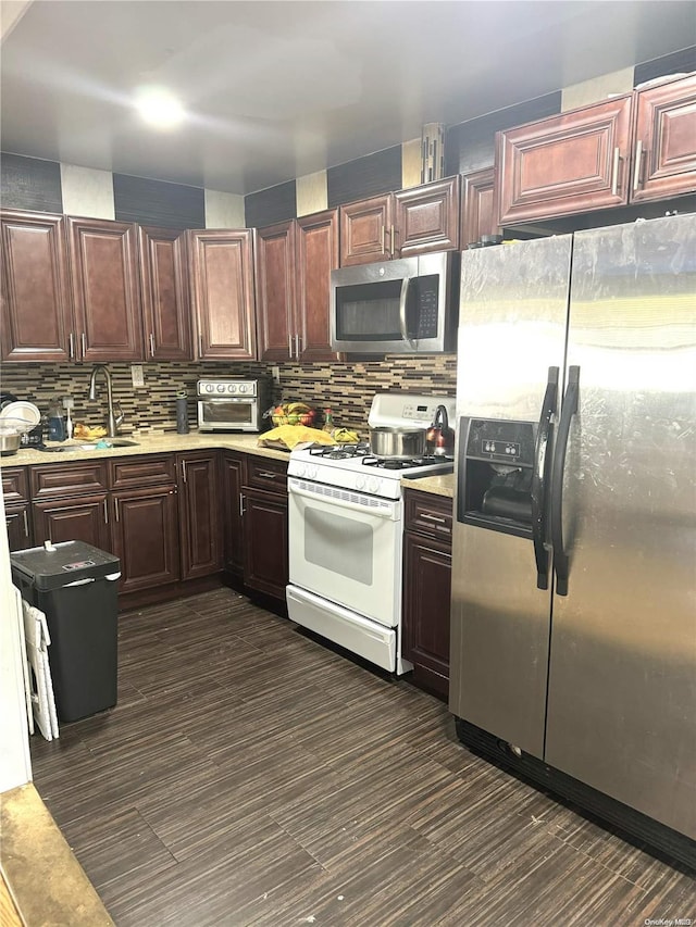 kitchen with decorative backsplash, dark hardwood / wood-style flooring, stainless steel appliances, and sink