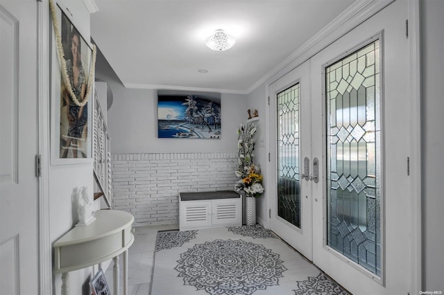 foyer with french doors, crown molding, and brick wall