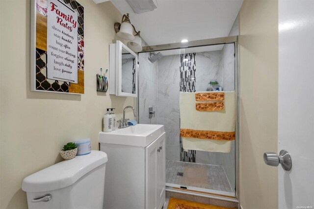 bathroom with vanity, toilet, and tiled shower