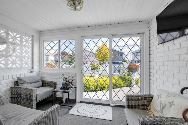 sunroom / solarium with a healthy amount of sunlight and wood ceiling