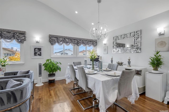 dining room featuring a notable chandelier, plenty of natural light, wood-type flooring, and high vaulted ceiling