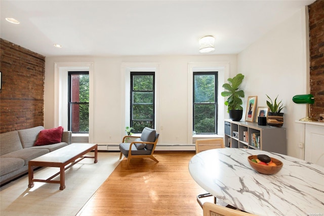 dining space featuring light hardwood / wood-style flooring and brick wall