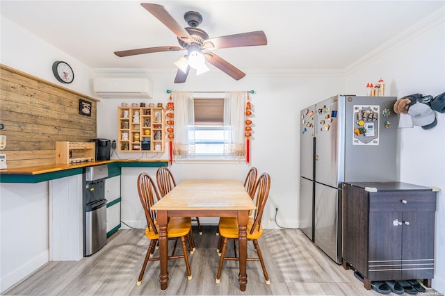 dining room with ceiling fan, ornamental molding, light hardwood / wood-style flooring, and a wall mounted AC