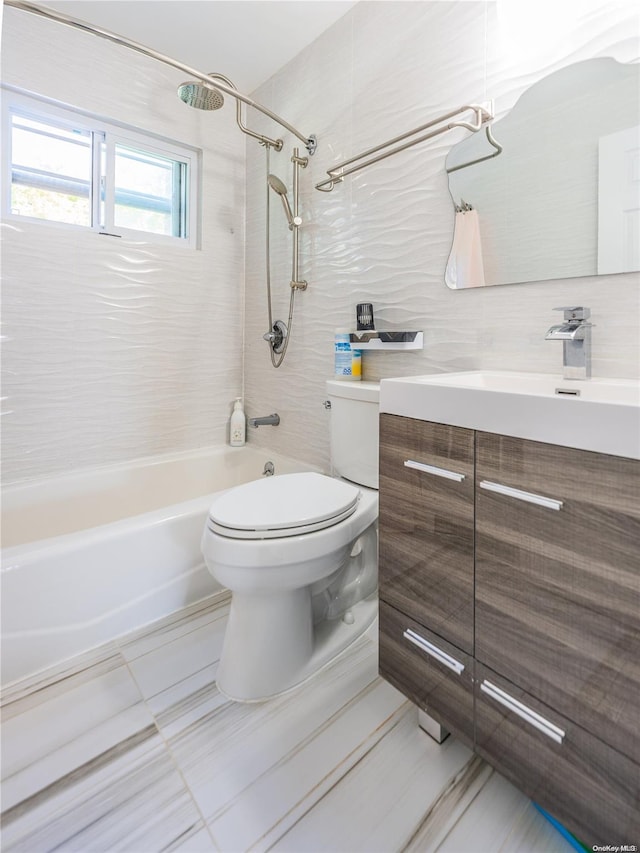 full bathroom with vanity, tiled shower / bath combo, toilet, tile walls, and tasteful backsplash