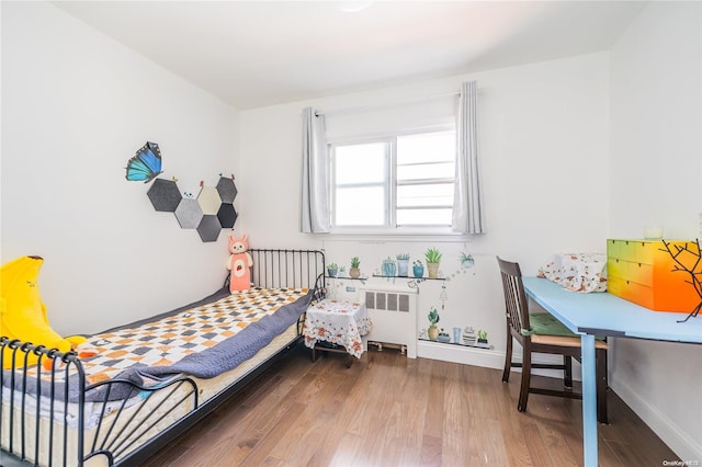 bedroom featuring hardwood / wood-style flooring and radiator