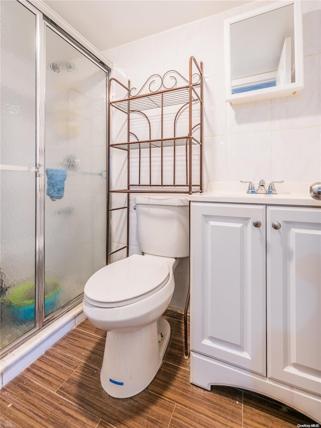 bathroom featuring walk in shower, vanity, hardwood / wood-style flooring, and tile walls