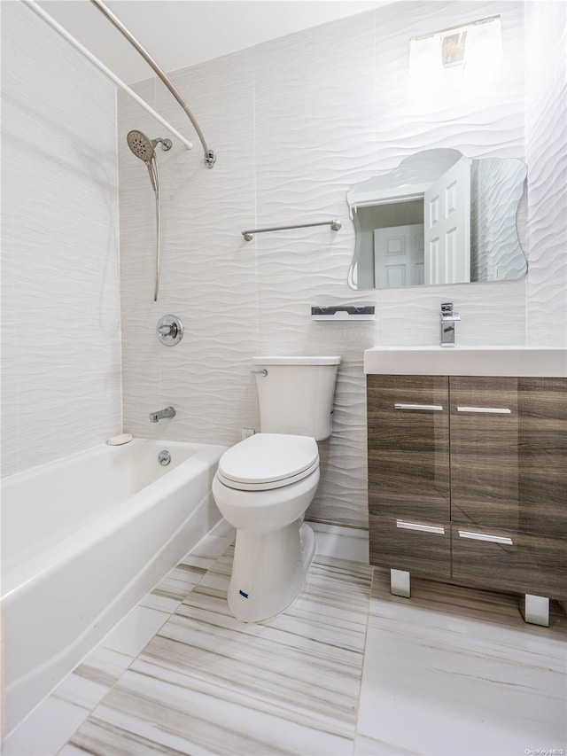 full bathroom with tiled shower / bath combo, tile patterned floors, toilet, vanity, and tile walls