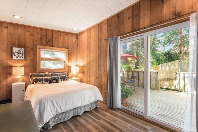 bedroom featuring dark hardwood / wood-style flooring and wood walls