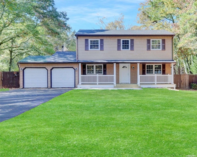 view of front of home featuring covered porch, a garage, and a front yard