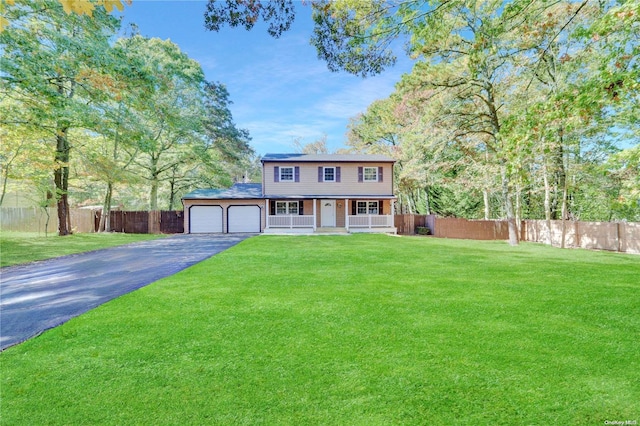 view of front of house featuring covered porch, a garage, and a front yard