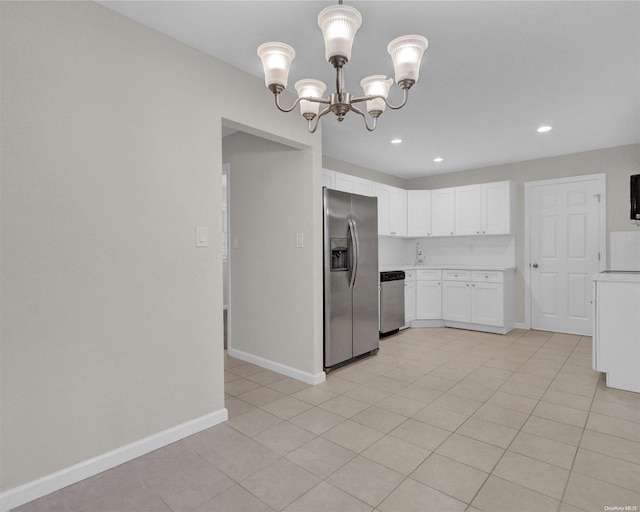 kitchen featuring white cabinets, appliances with stainless steel finishes, a notable chandelier, and light tile patterned flooring