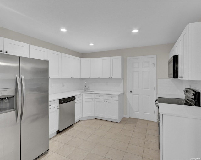 kitchen with white cabinets, decorative backsplash, sink, and stainless steel appliances