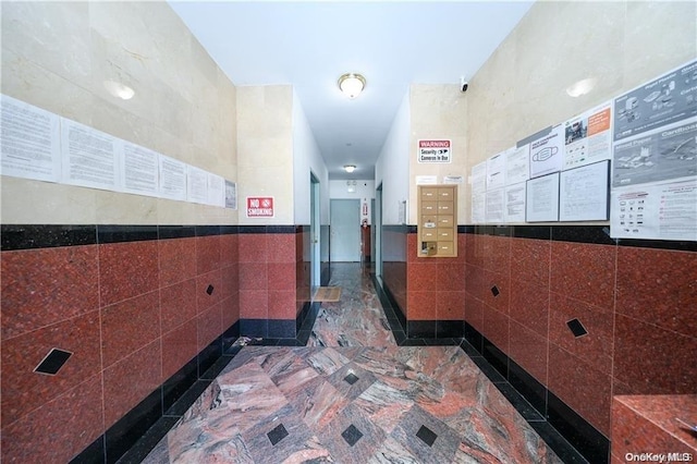 hall featuring tile walls