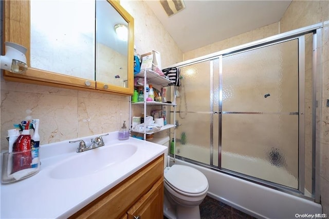 full bathroom with vanity, toilet, combined bath / shower with glass door, and decorative backsplash