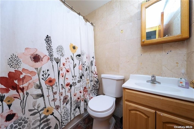 bathroom with vanity, toilet, tile walls, and curtained shower