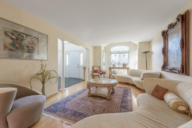 living room featuring ornate columns and light hardwood / wood-style floors