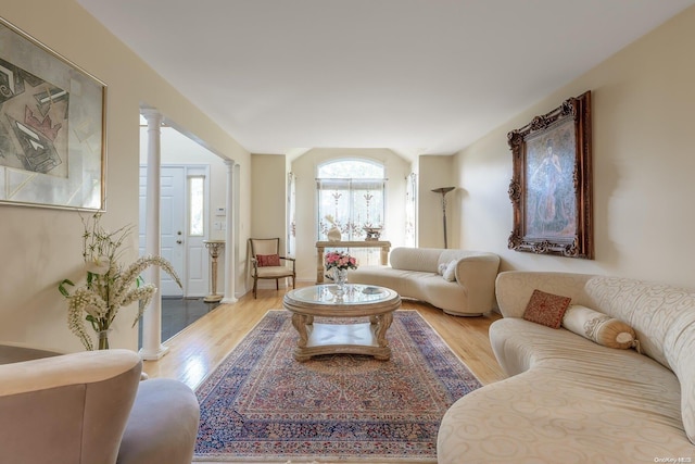 living room featuring light hardwood / wood-style floors and ornate columns