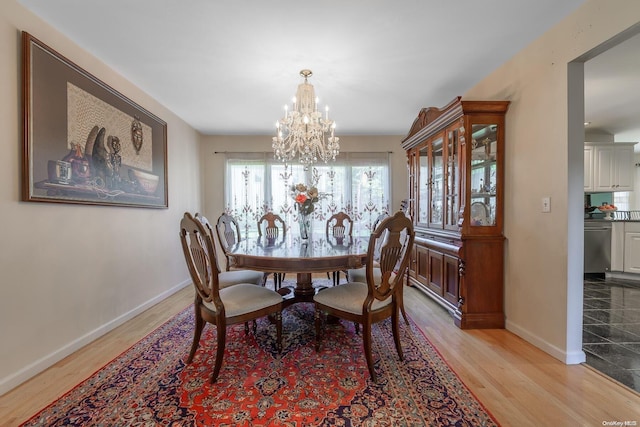 dining space featuring light hardwood / wood-style floors and an inviting chandelier