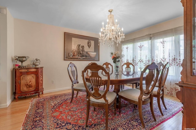 dining area featuring a notable chandelier and light wood-type flooring