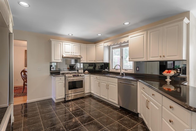 kitchen with white cabinets, stainless steel appliances, kitchen peninsula, and sink