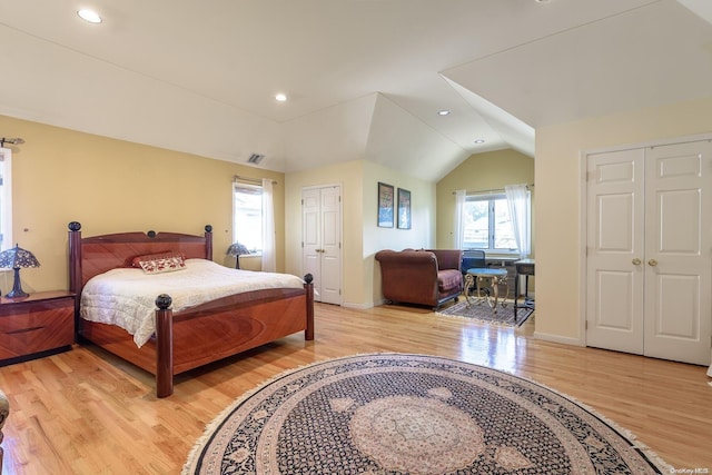 bedroom with lofted ceiling and light wood-type flooring